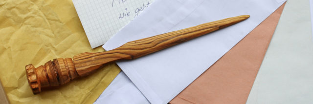 A letter opener in wood and open mail.