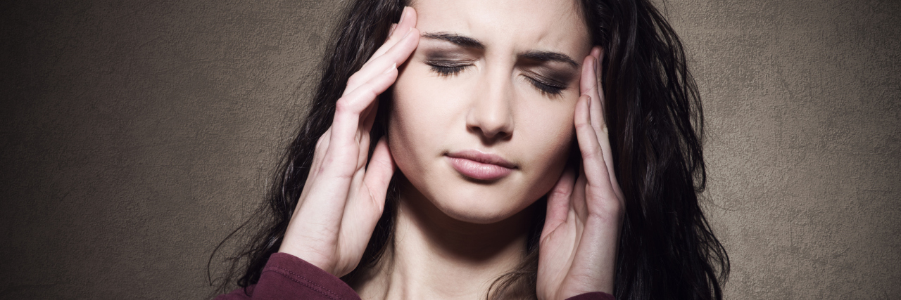 Signs You May Have Dysautonomia woman holding her head