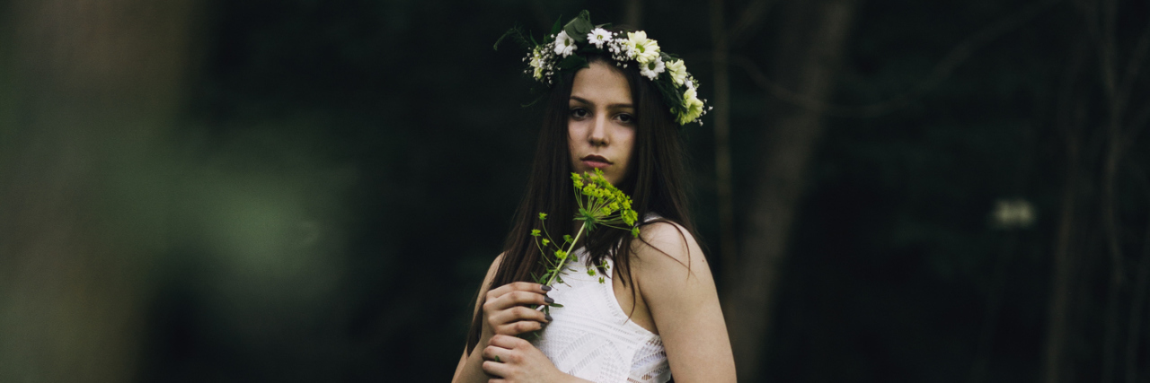 Why I Feel Anxious Before Every Doctor's Appointment A woman in the woods, wearing a white dress.