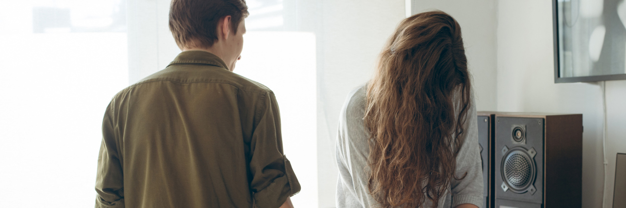 When Anxiety Makes Me Insecure in Relationships woman looking down while man stands next to her. they are having a problem in their relationship