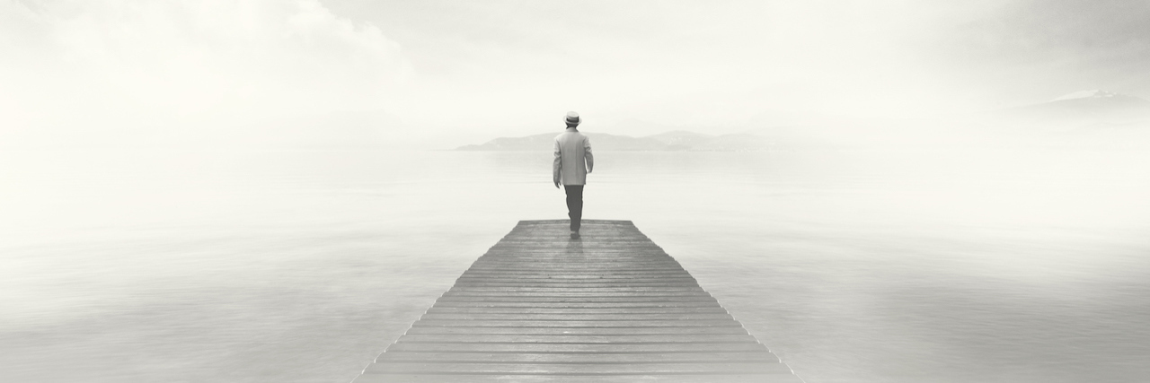 I Didn't Realize I Had Depression Because I Felt Nothing Man walking on a boardwalk in the fog