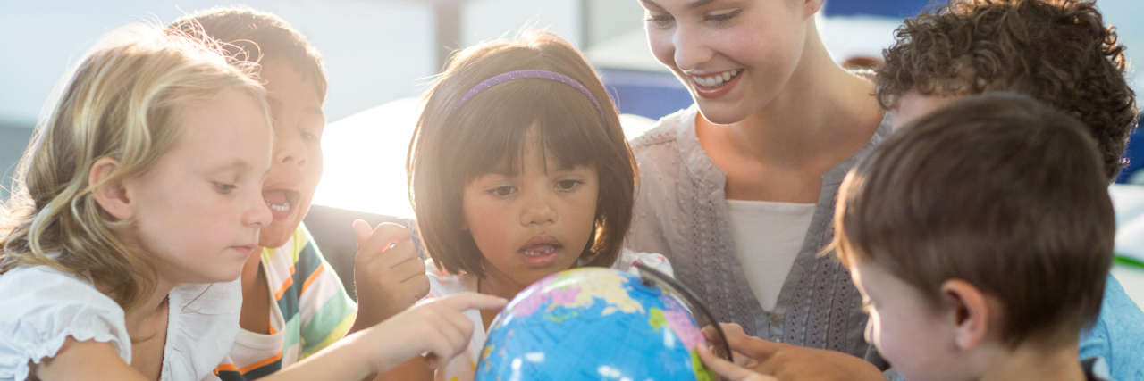 Being a Special Education Teacher With Adult-Diagnosed Autism Teacher looking at schoolchildren touching globe.
