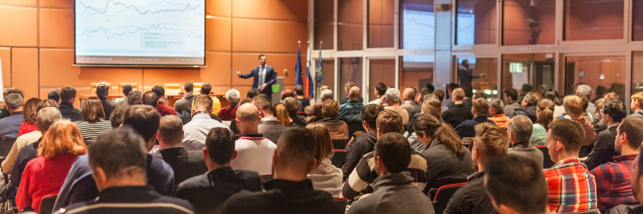 Things We Learned at the Autism Society Conference Speaker giving a talk in conference hall.