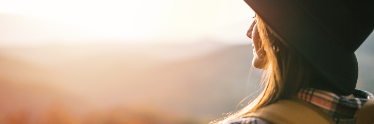 How Gratitude Helps Me Live With Lupus woman standing outside enjoying the sun in the mountains