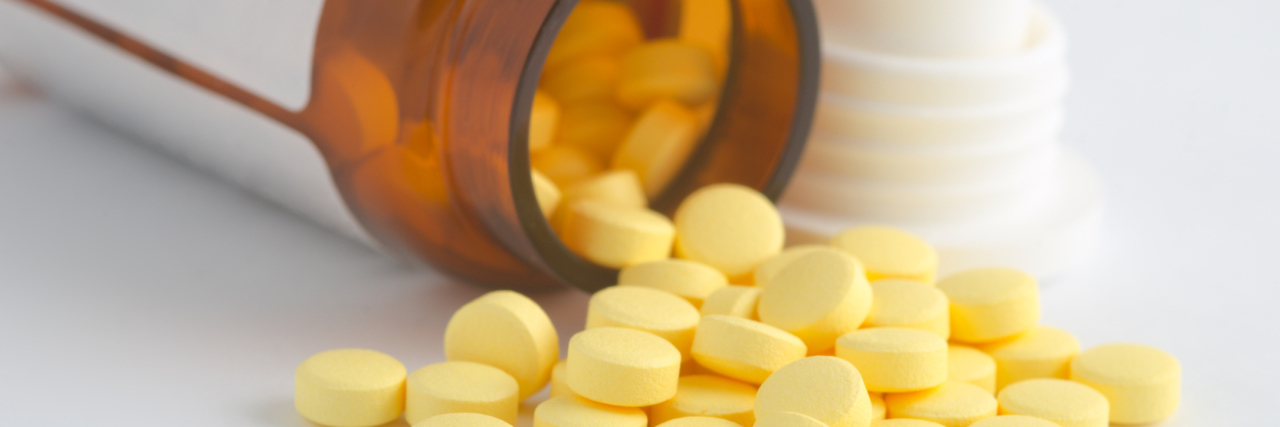 opioid pills spilling out of a medication bottle