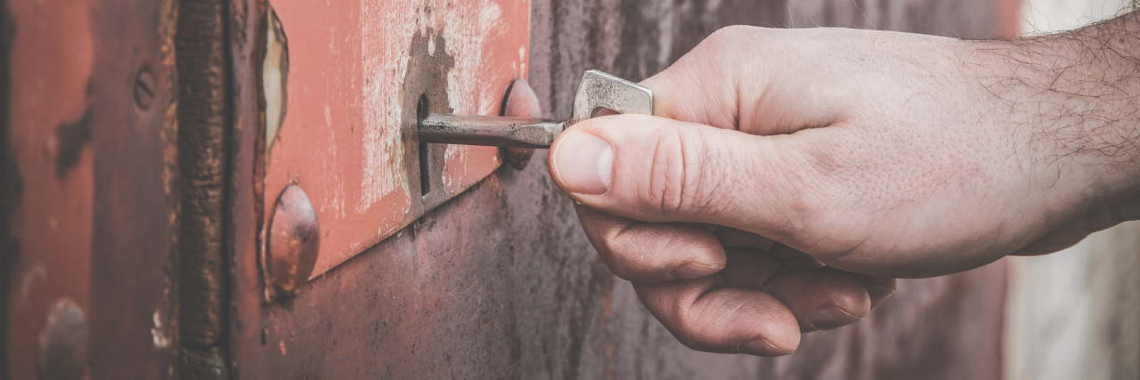 Why I Keep My Cystic Fibrosis Behind Closed Doors A man locking a door with a skeleton key.