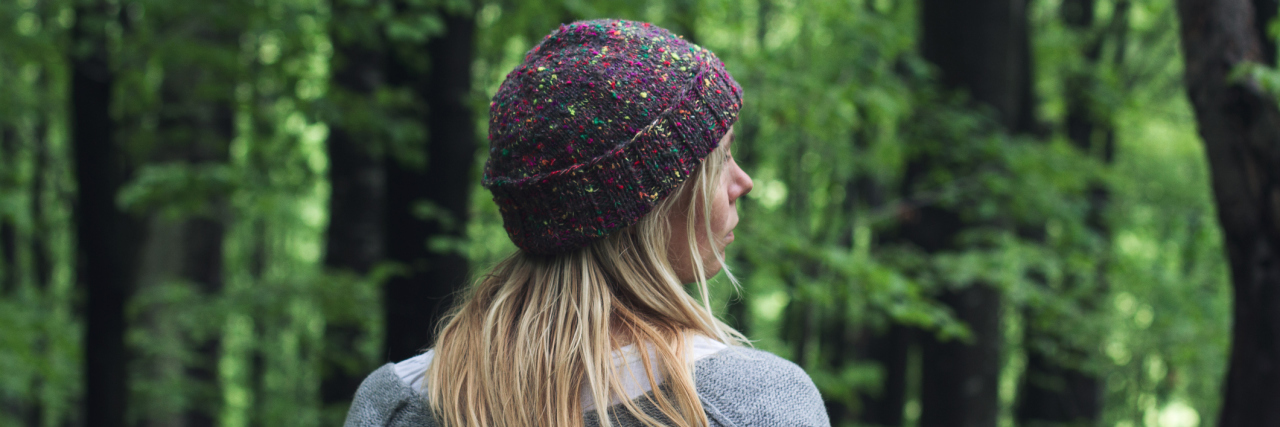 What I've Learned From Having a Seizure Disorder woman in a beanie walking outside in a forest