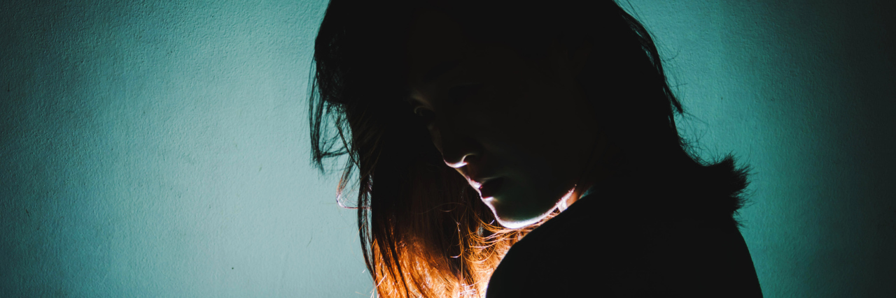 Why Being 'Used to' Fibromyalgia Pain Doesn't Make It Easier silhouette of woman standing in the dark with light shine behind