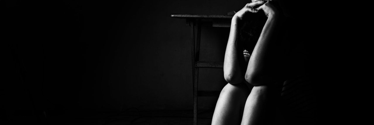 What My Panic Attack Really Feels Like a woman sitting on ground with arm around lower head, sexual violence , sexual abuse, human trafficking concept with shadow edge in white tone