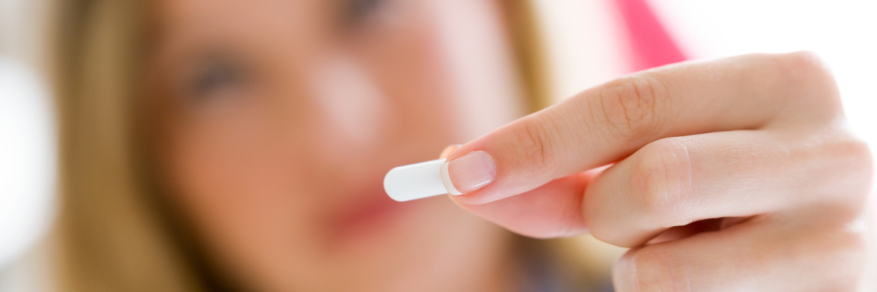 When the Antidepressant Doesn't Work Portrait of depressed young woman taking pills at home.