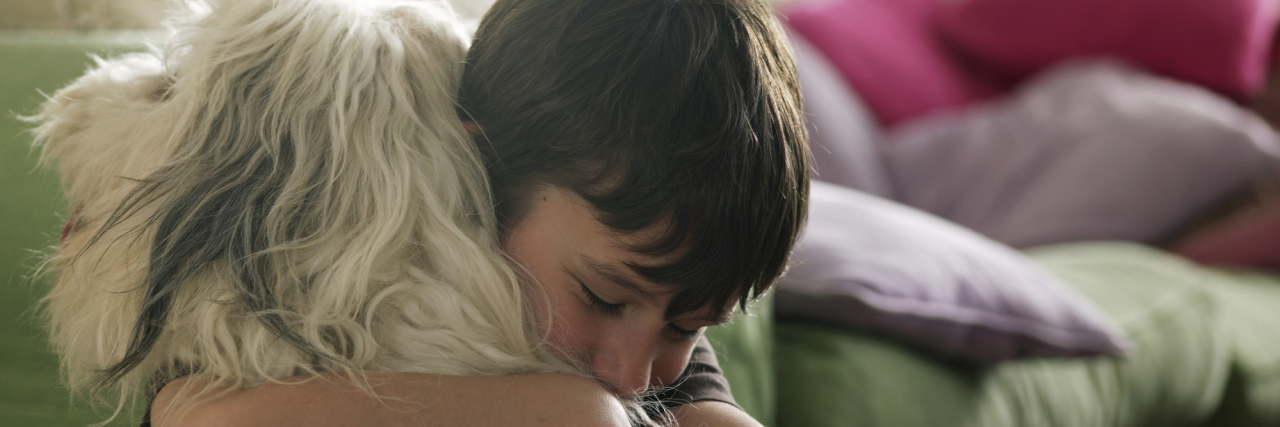 Things to Consider Before Getting a Service Dog Boy hugging his dog.