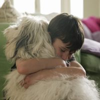 Boy hugging his dog.