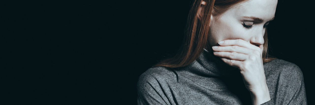 Why It's Important to Start Saying "Suicide" More Woman covering her mouth