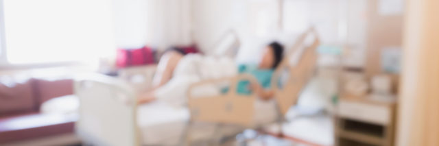 blurry image of a woman lying in a hospital bed