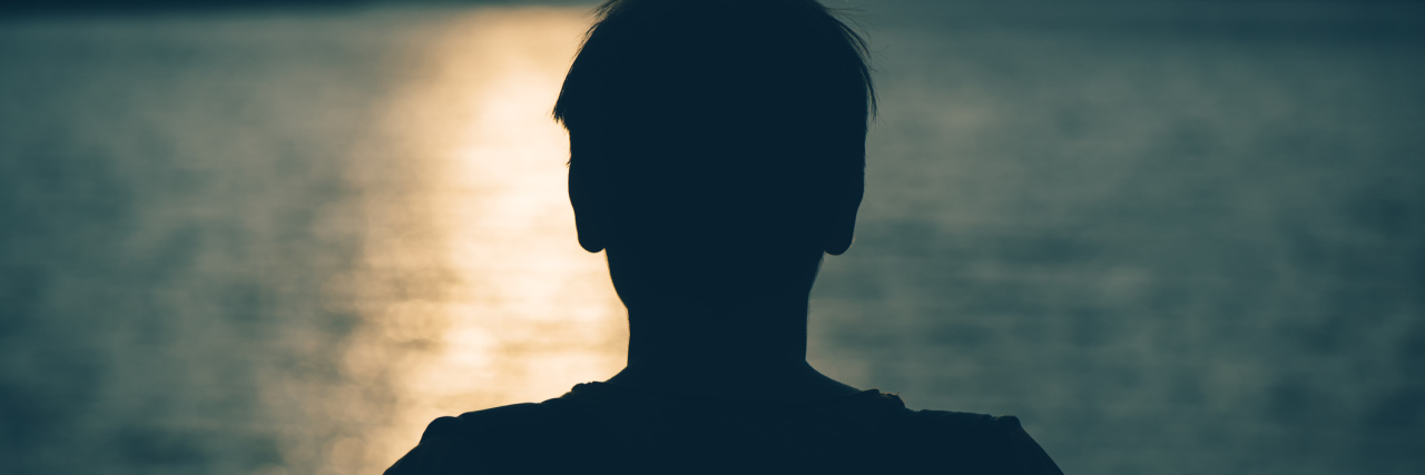 Mourning and Grieving for the Life You Had Before Chronic Illness silhouette of a woman standing by a lake