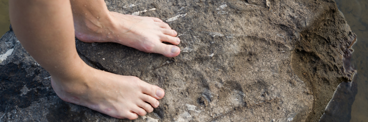 Enjoying Sensations Other Than Pain With Lupus woman standing barefoot on a rock