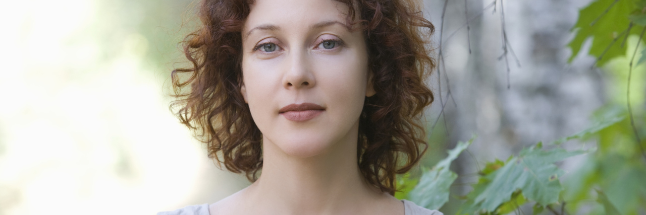 Surviving Lyme Disease and Tularemia woman standing outside amongst leaves