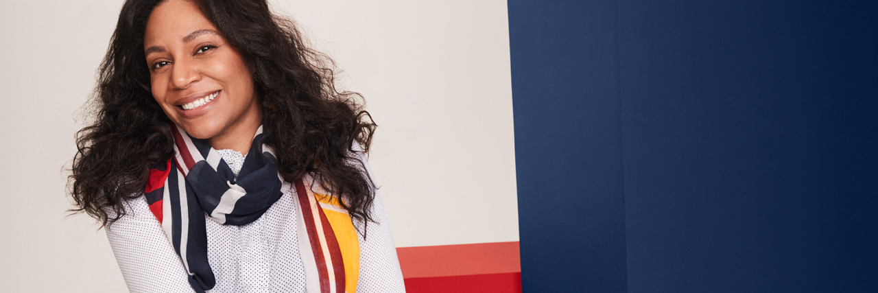 Tommy Hilfiger Launches Line of Adaptive Clothing for Adults Photo of a woman in a wheelchair wearing a Tommy Adaptive Shirt and skirt.