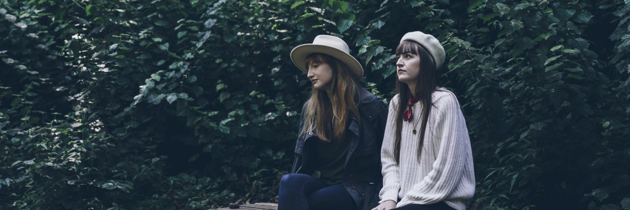 When My Panic Attack Unexpectedly Sparked a Beautiful Friendship two woman sit together on a bench in the fall