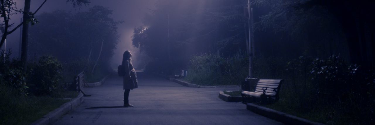 When BPD Makes You Feel Haunted by Your 'Favorite Person' woman in darkness misty spooky night looking up at light in sky
