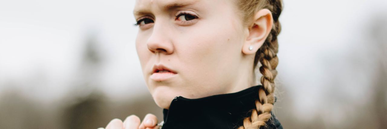 Don't Call Me 'Brave' for Struggling With Mental Illness girl with braids looking angry