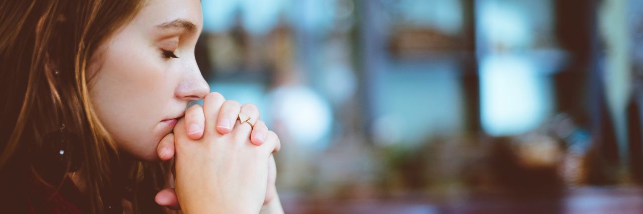 What Reminds My Anxious Mind to Embrace the Gift of Life woman with brown hair sits with her hands crossed in front of her face