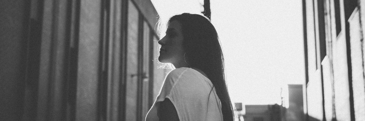 black and white photo of a woman in an alley