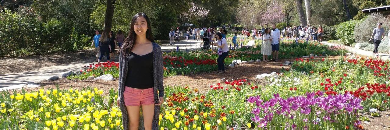 How I Knew I Wasn't Strongly Recovered From My Eating Disorder a woman stands in a garden of flowers