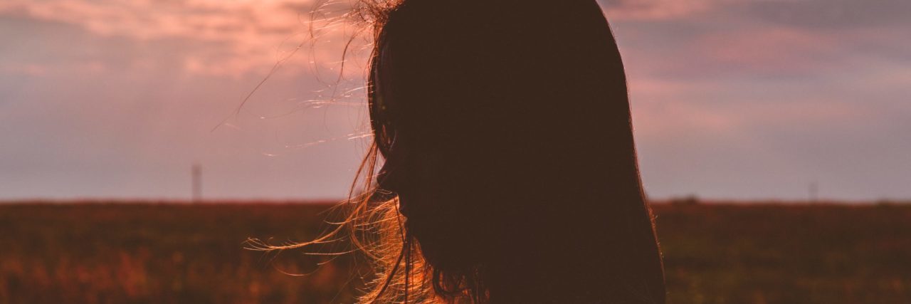 woman silhouetted in light at sunset