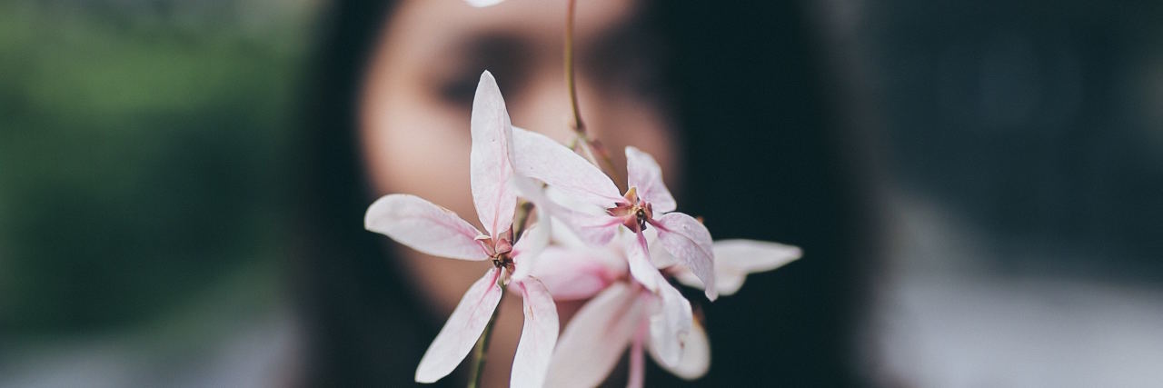 woman flowers in front of face