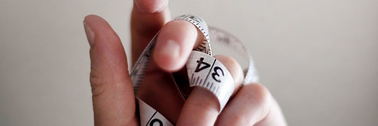 9 Things I Wish I Told the Doctor Who 'Prescribed' Me Weight Loss hand holding tape measure