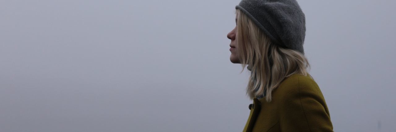 blonde woman standing in profile in mist