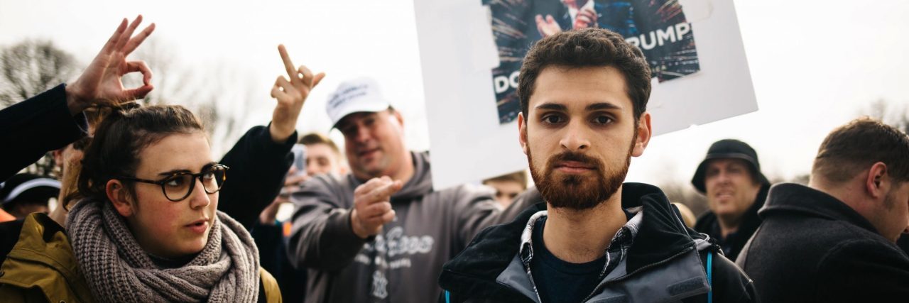 When Mental Illness Makes It Hard to Protest Against Injustice male protestor at donald trump inauguration looking at camera