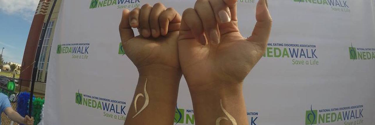 To the Woman With an Eating Disorder Recovery Tattoo hands with NEDA recovery symbol on their wrists