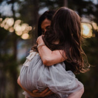 Mother and daughter hugging, faces are not visible for either of them.