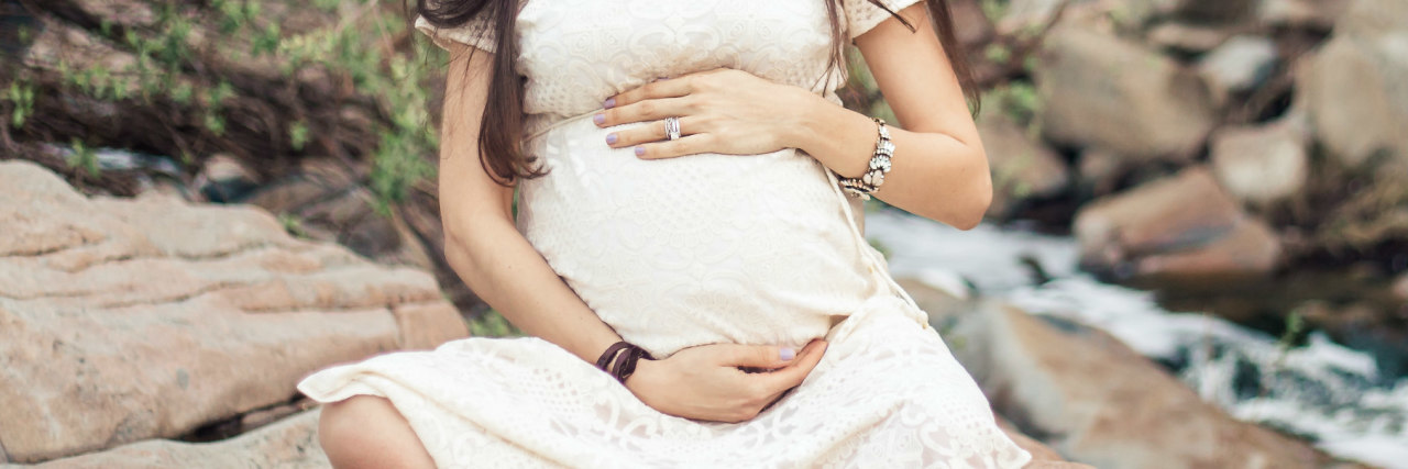 pregnant woman holds her belly