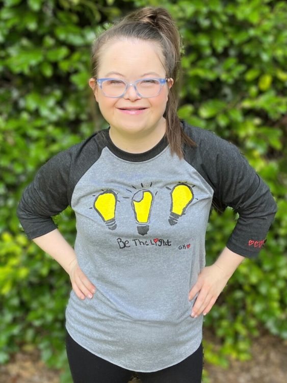 Grace wearing a Be the Light raglan.