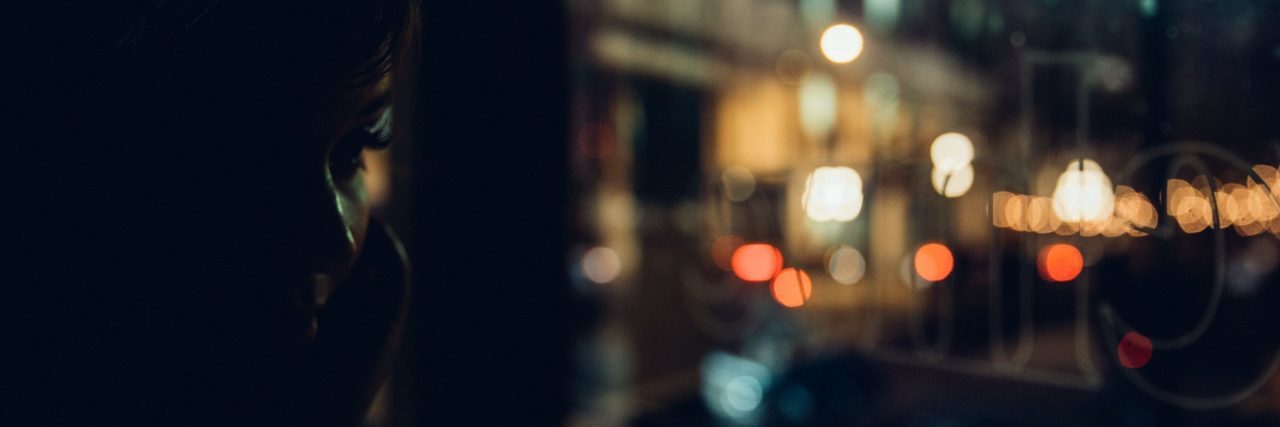 Why We Need to Treat Anxiety Like Any Other Illness girl mostly in darkness beside city lights