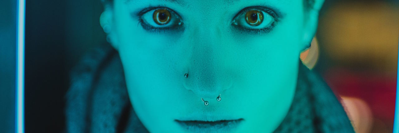 5 Things I Wish People Without Anxiety Would Say When I'm Struggling woman lit by neon blue sign staring at the camera