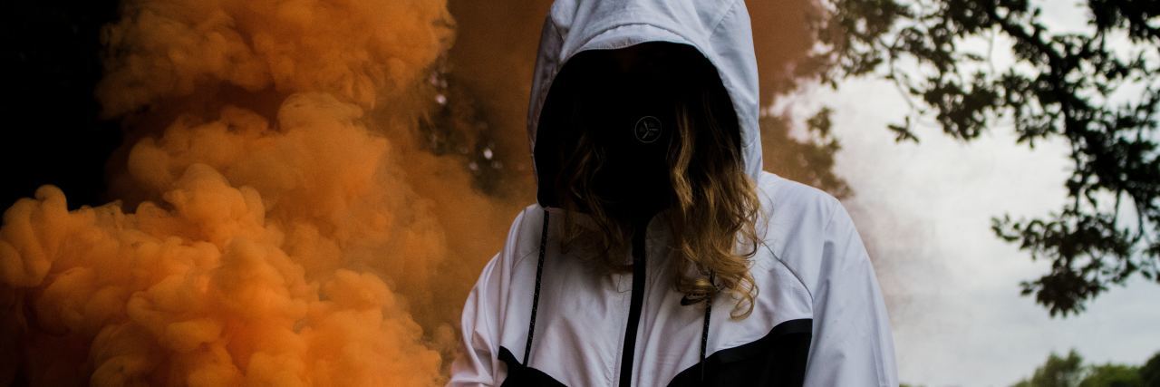 To Those Who Choose Not to Openly Share Their Mental Health Struggles person stands with their head down in a cloud of smoke