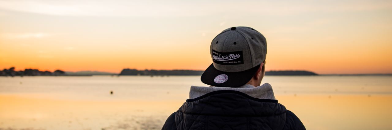 a man stands in front of a sunset