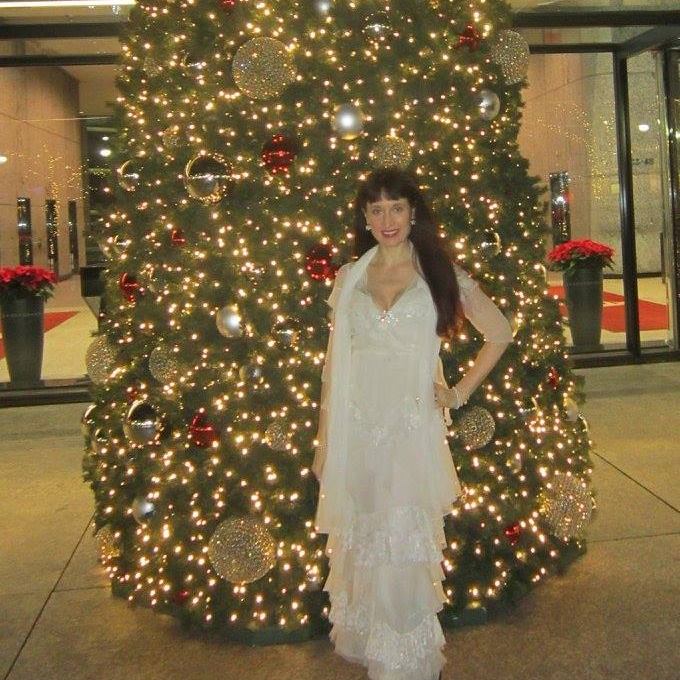 woman standing in front of a christmas tree