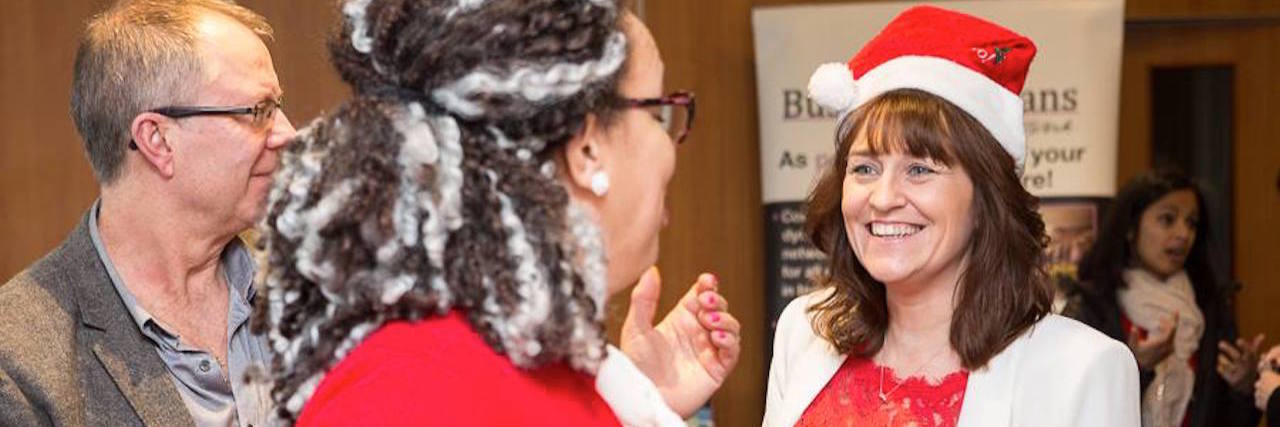 How to Enjoy the Holidays When You're Chronically Ill A photo of the writer wearing a Santa hat at a Christmas party.