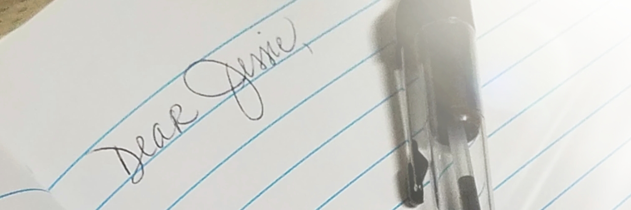 a pen on a notebook. The lines "Dear Jessie" are written in the notebook