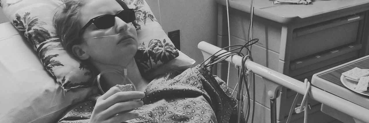 black and white photo of a woman lying in a hospital bed