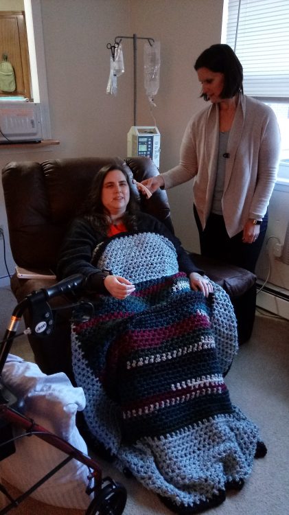 woman receiving an infusion while her nurse stands by her side