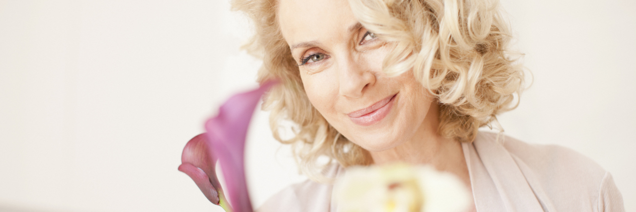 Healthy Habits to Develop When You're Diagnosed With Fibromyalgia An older woman holding flowers.