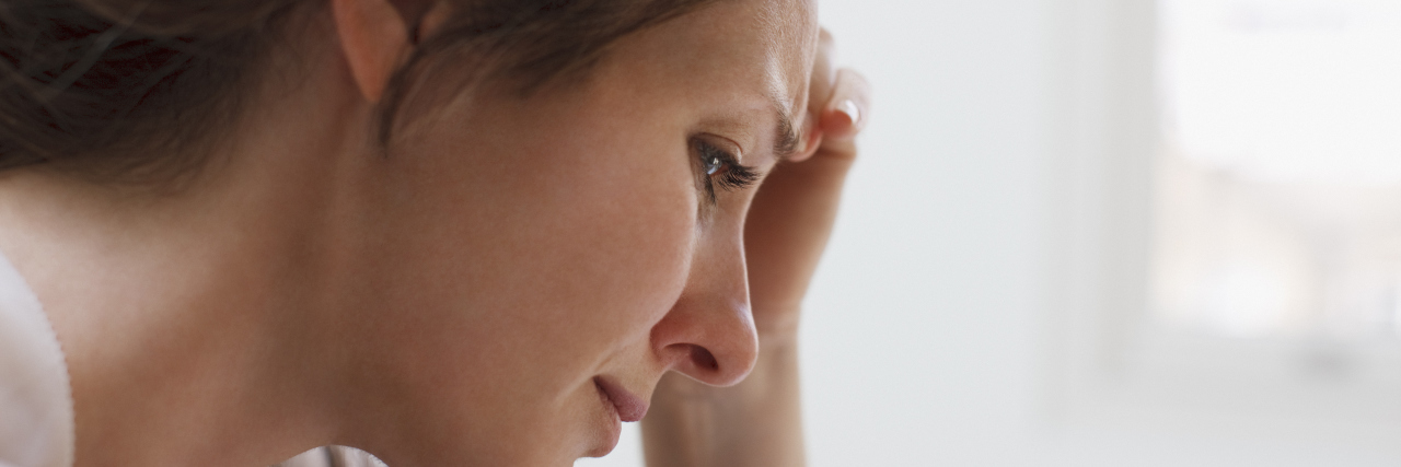 Depressed woman with head in hands