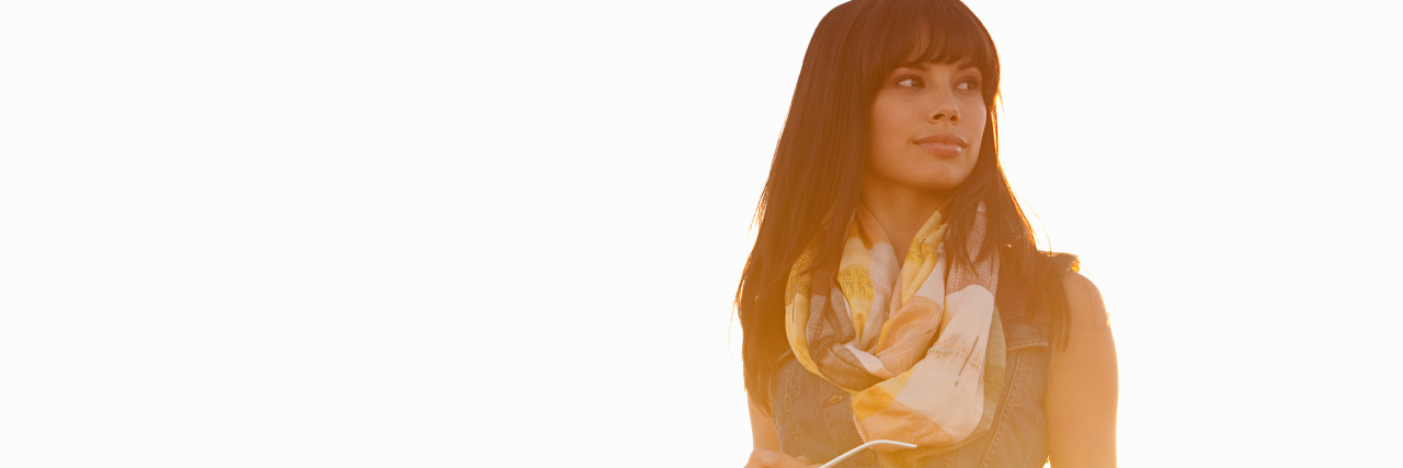 Feeling Happy and Relieved to Receive Gastroparesis Diagnosis woman standing in the sunlight holding glasses and smiling