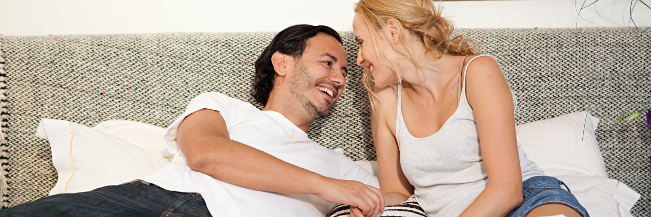 Coping With Painful Sex Due to Endometriosis a couple sitting in bed laughing